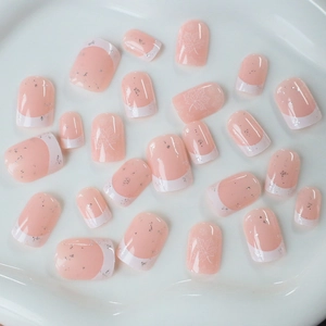 Short French tip press-on nails with white maple leaf motifs and silver glitter accents