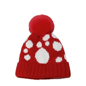 Makroaufnahme der roten Strickmütze mit weißen Punkten und flauschigem Kunstfell-Bommel