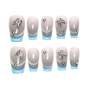 Faux ongles French cat-eye bleu avec papillon en métal argenté et strass brillants
