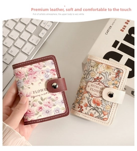 Close-up of vintage floral leather card holders with metal snap closure and fine stitching