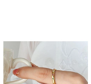 Detailed view of a gold eternity ring with colorful gems worn on a finger