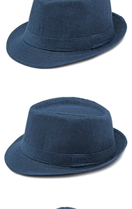 Detail of navy blue straw fedora hat featuring woven texture and classic dented crown