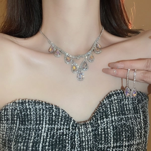 Silver teardrop necklace and earrings set with sparkling crystals on female model