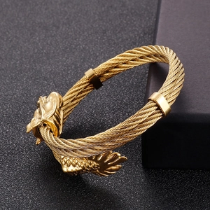 Detail of 8mm gold dragon head cuff bracelet with twisted cable wire punk design