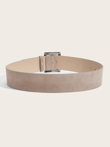 Gros plan d'une large ceinture en daim kaki avec boucle carrée métallique et texture mate