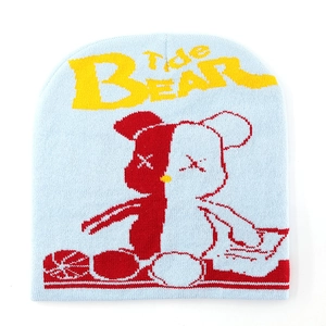 Detailed close-up of light blue knitted beanie with bear motif and Tide BEAR embroidery