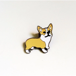 Détail macro d'une jolie broche en émail en forme de Corgi jaune et blanc