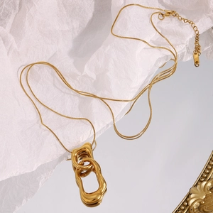 Detail of double layered gold snake chain necklace with irregular geometric pendant