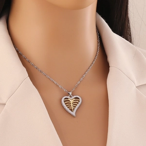 Collier avec pendentif cœur bicolore or et argent serti de cristaux sur un mannequin