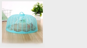 Detail of blue plastic food cover with mesh design and ergonomic handle on wooden table