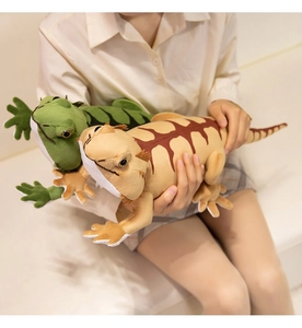 Close-up of green and khaki plush bearded dragon lizard toys held to show texture and size