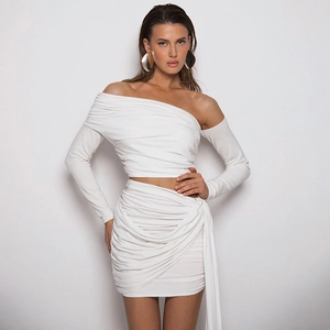 Detail view showing white pleated off-shoulder long sleeve top and matching bodycon skirt set