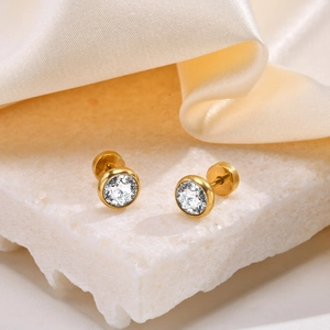 Macro shot of gold stainless steel stud earrings featuring round clear cubic zirconia