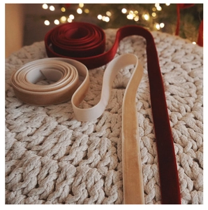 Macro shot of high-quality red and champagne velvet ribbons on a white knit background