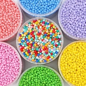 Colorful glass seed beads sorted in clear jars for DIY jewelry making and embroidery
