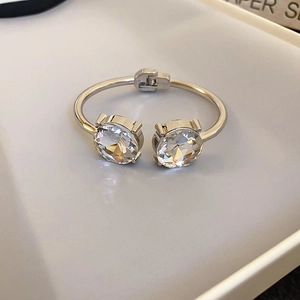 Detailed view of polished silver bangle with large round crystals in claw setting