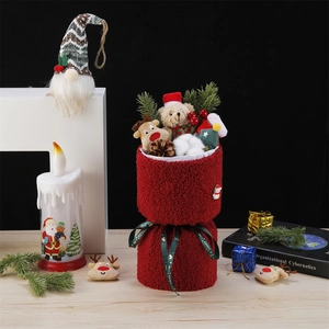 Christmas plush dolls and pine decorations in a red velvet gift bag with Merry Christmas ribbon
