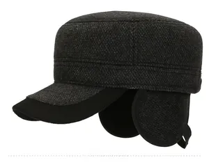 Dettaglio cappello piatto grigio scuro con paraorecchie e stemma Sport in metallo