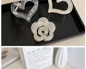 Detailed view of heart-shaped and camellia resin hair clips with metal springs