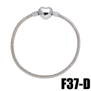 Macro shot of silver heart clasp snake chain bracelet with detailed spiral texture