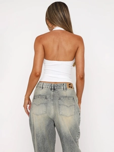 Vue de dos d'un crop top dos nu blanc associé à un jean en denim délavé vintage