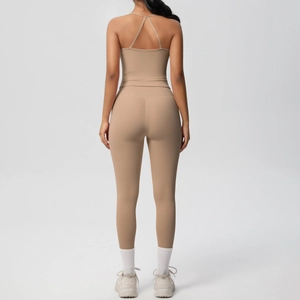 Close-up of beige high-waist yoga leggings and cross-back sports bra with matte texture
