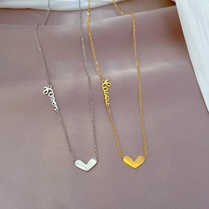 Dettaglio di collane in acciaio al titanio oro e argento con ciondoli a cuore Love e Forever