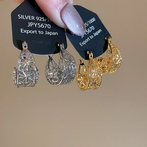 Detailed macro view of 18k gold and silver hollowed star earrings with 925 silver posts