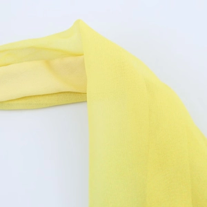 Detailed macro view of yellow chiffon fabric showing light texture and sheer quality