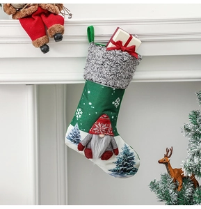 Green and grey knit Christmas gnome stockings with white snowflakes hanging on fireplace