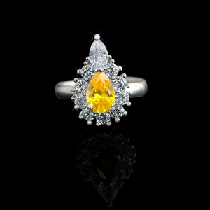 Macro detail of silver ring featuring a pear-cut yellow stone and clear diamond accents