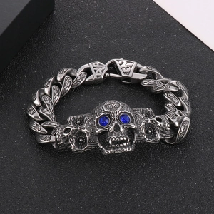 Détail macro du bracelet punk tête de mort avec yeux bleus et gravures florales
