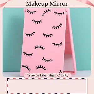 Pink portable folding makeup mirror with cute eyelash pattern on matte rectangular case