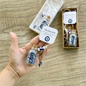 Detail of blue evil eye glass bottle in decorative gift box with protective message card