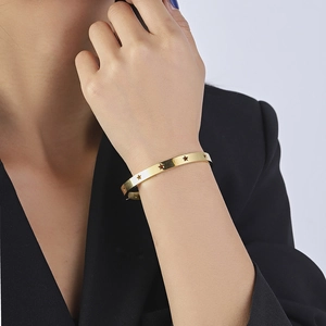 Detail shot of 18k gold plated stainless steel bangle with hollow star pattern