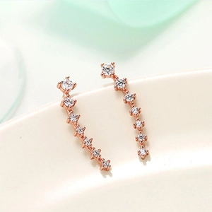 Macro detail of rose gold curved stud earrings with shimmering white cubic zirconia