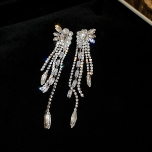 Vue détaillée de l'éclat des boucles d'oreilles longues à pampilles avec gouttes de cristal.