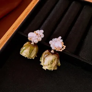 French vintage 18k gold plated pearl and green rose bud earrings on black velvet