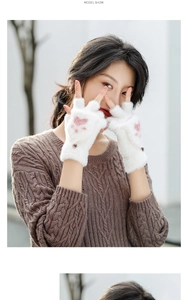 Close-up of white plush fingerless gloves with pink cat paw design and side metal button
