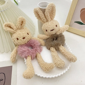 Detailed view of plush bunny hair accessories in pink and brown soft fleece textures