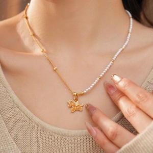 Detail of 18k gold-plated pearl necklace featuring a winged Pegasus pendant with zircons