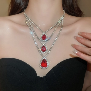 Dettaglio macro della collana tripla in argento con pendenti a goccia rossi