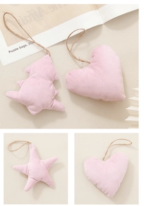 Vista dettagliata di ornamenti in peluche rosa a forma di cuore e stella con corda di iuta