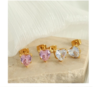 Macro shot of heart-cut zircon earrings in pink and white with gold prongs