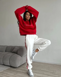 Detail of red crewneck sweatshirt with embroidery and side-stripe joggers set