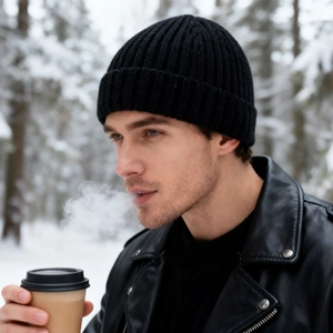 Black ribbed knit beanie hat for men and women shown in a snowy winter forest setting