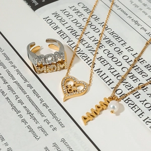 Detailed view of gold Mom and Mama jewelry set with pearls and rhinestones on white background