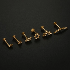 Detailed view of six 16G gold medical stainless steel labret and cartilage studs