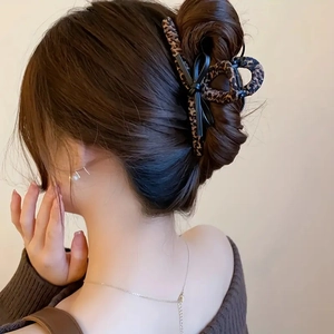 Elegant leopard print bow hair claw clip styled on a low bun for a vintage autumn look