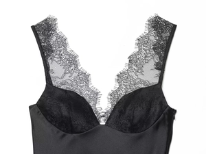 Detailopname van zwarte satijnen camisole met fijn wimperkant en zijdezachte textuur